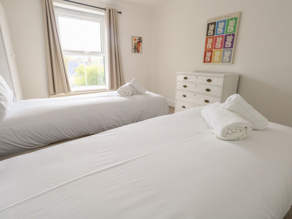 A bedroom with two beds and a dresser at Millmead House in Portesham