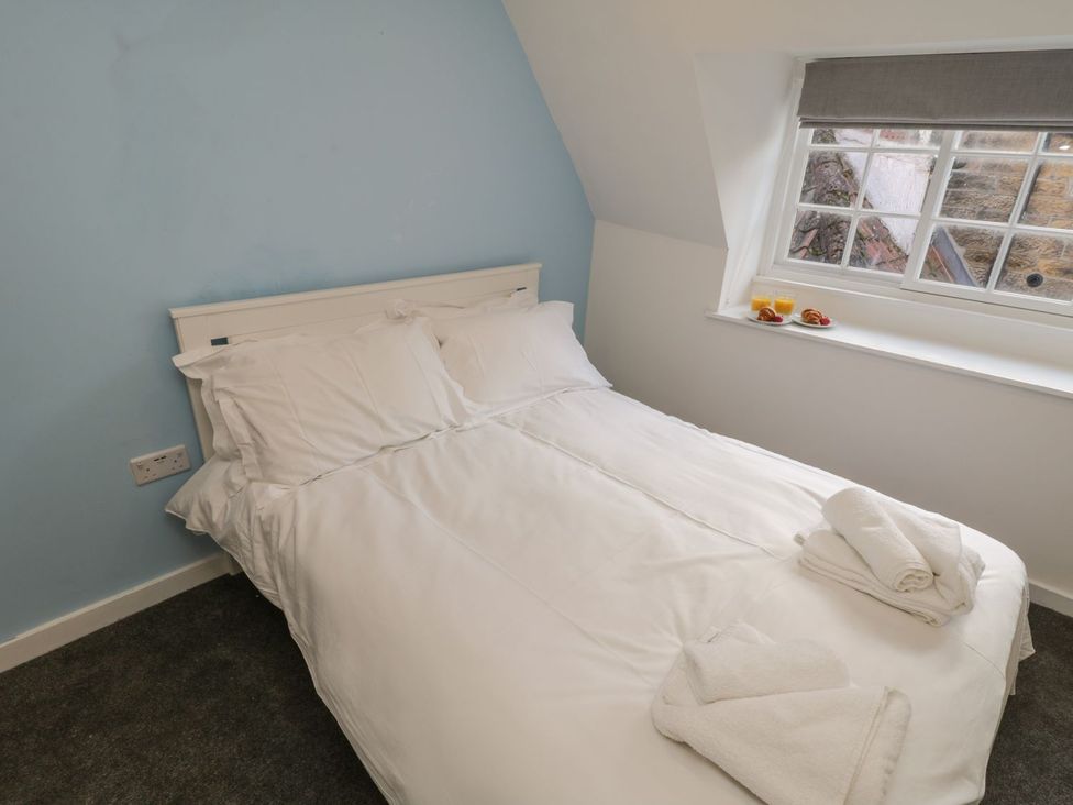 A bedroom with a bed and window at 47A Baxtergate Whitby