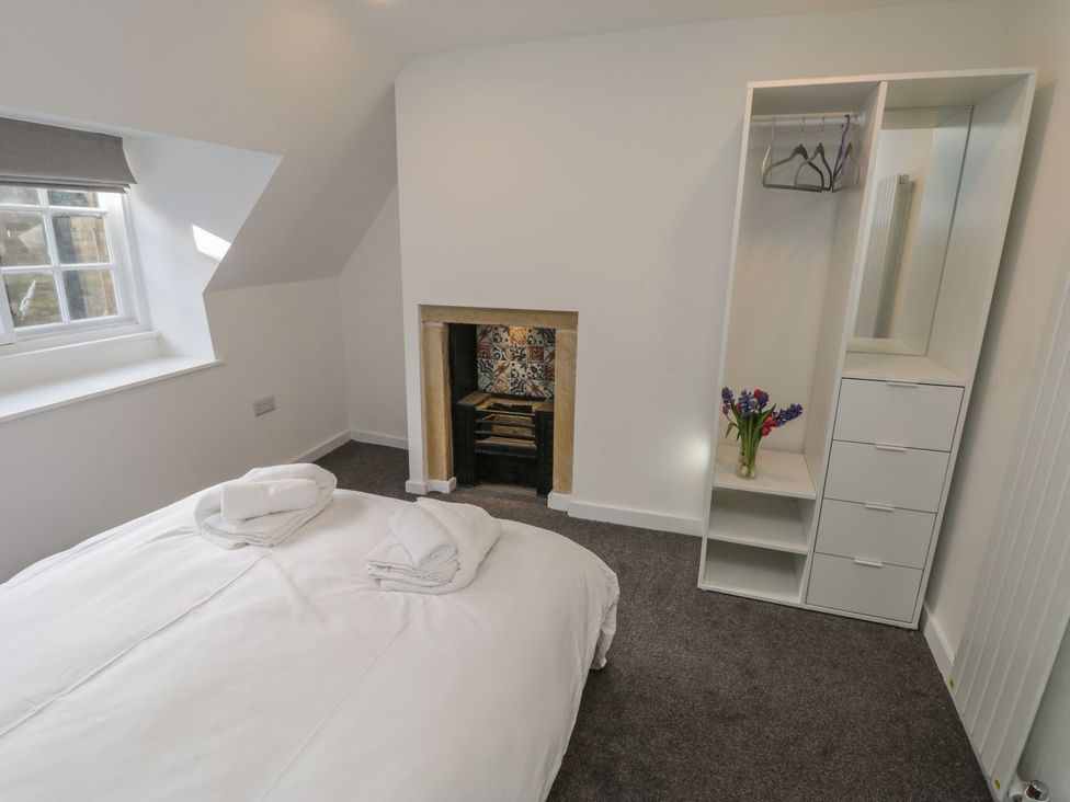 A bedroom with a bed and shelves at 47A Baxtergate Whitby