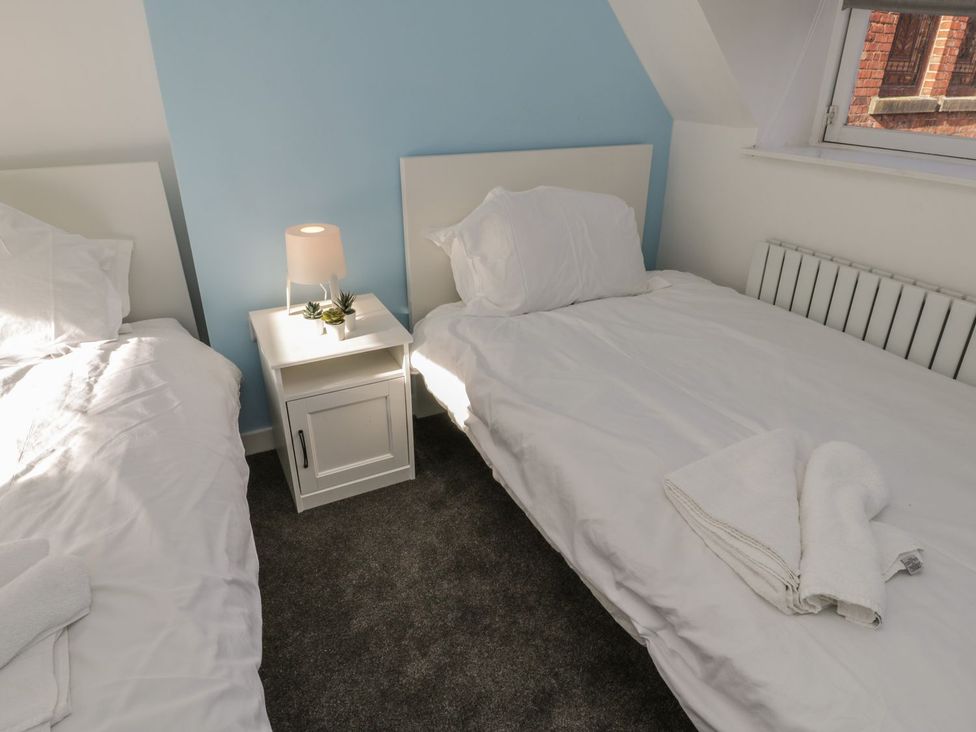 A bedroom with two beds and a nightstand at 47A Baxtergate, Whitby