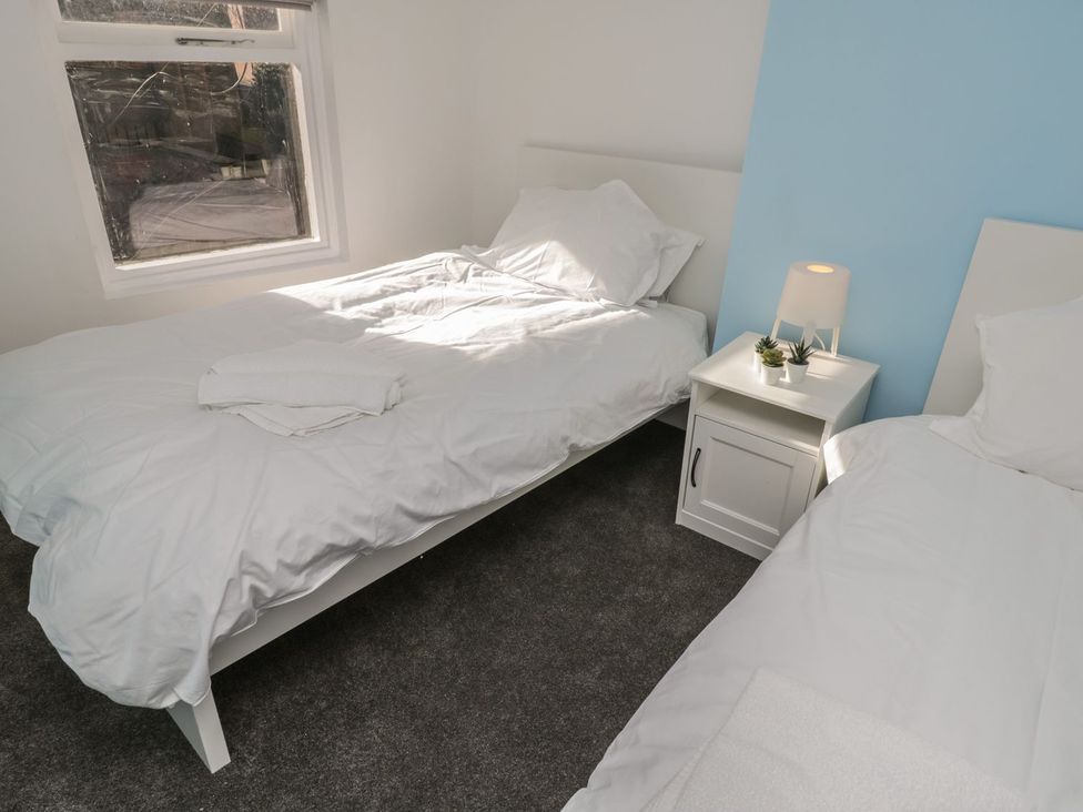 A bedroom with two beds and a nightstand at 47A Baxtergate in Whitby