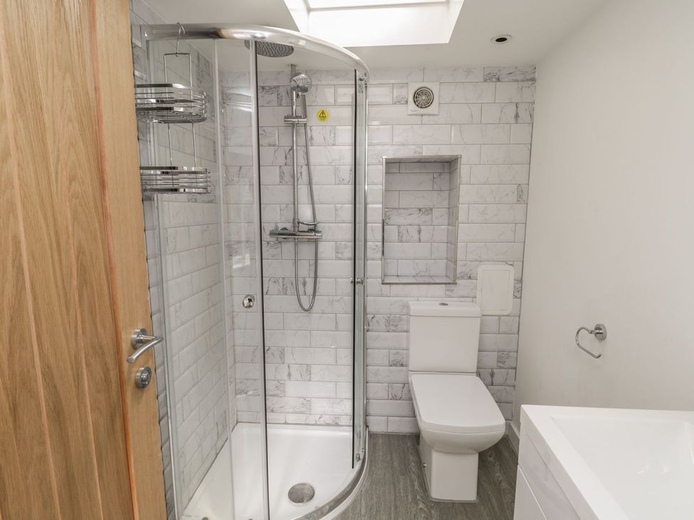 A bathroom with a shower, toilet, and sink at 47A Baxtergate Whitby