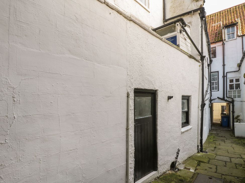 An outdoor area with a white wall and a door at 47A Baxtergate, Whitby
