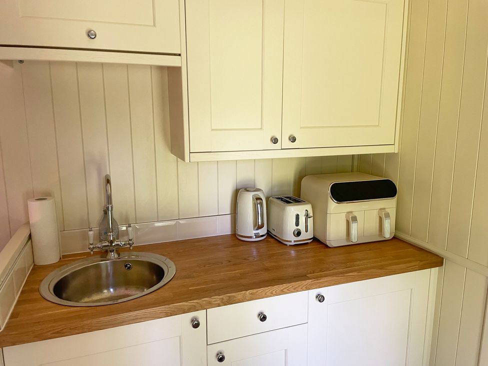 A kitchen with a sink and appliances at The Shephards Hut 