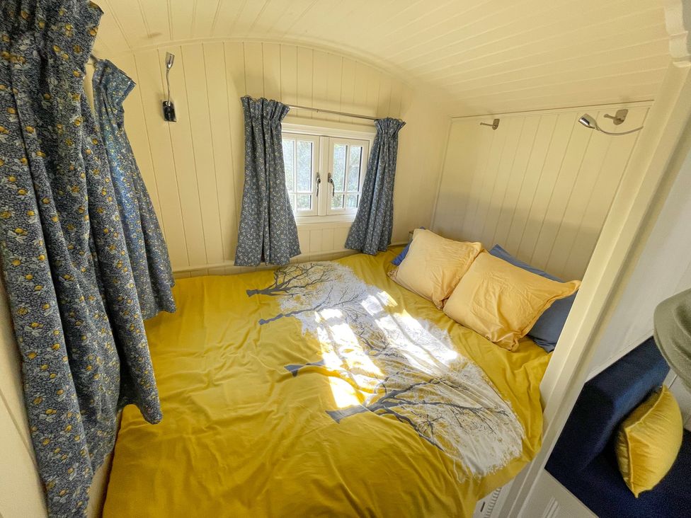 A bedroom with a bed and curtains at The Shephards Hut
