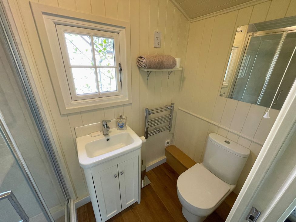 A bathroom with a sink, toilet and window at The Shephards Hut 