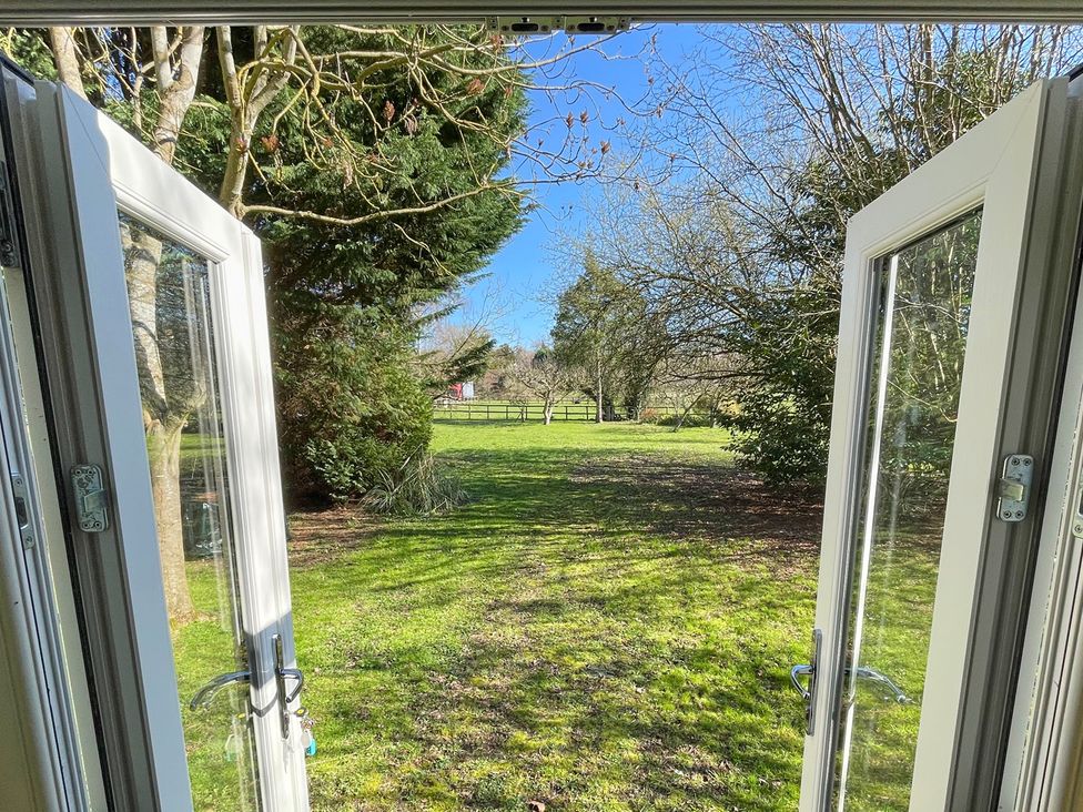 A view of a garden with trees and a fence at The Shephards Hut in 