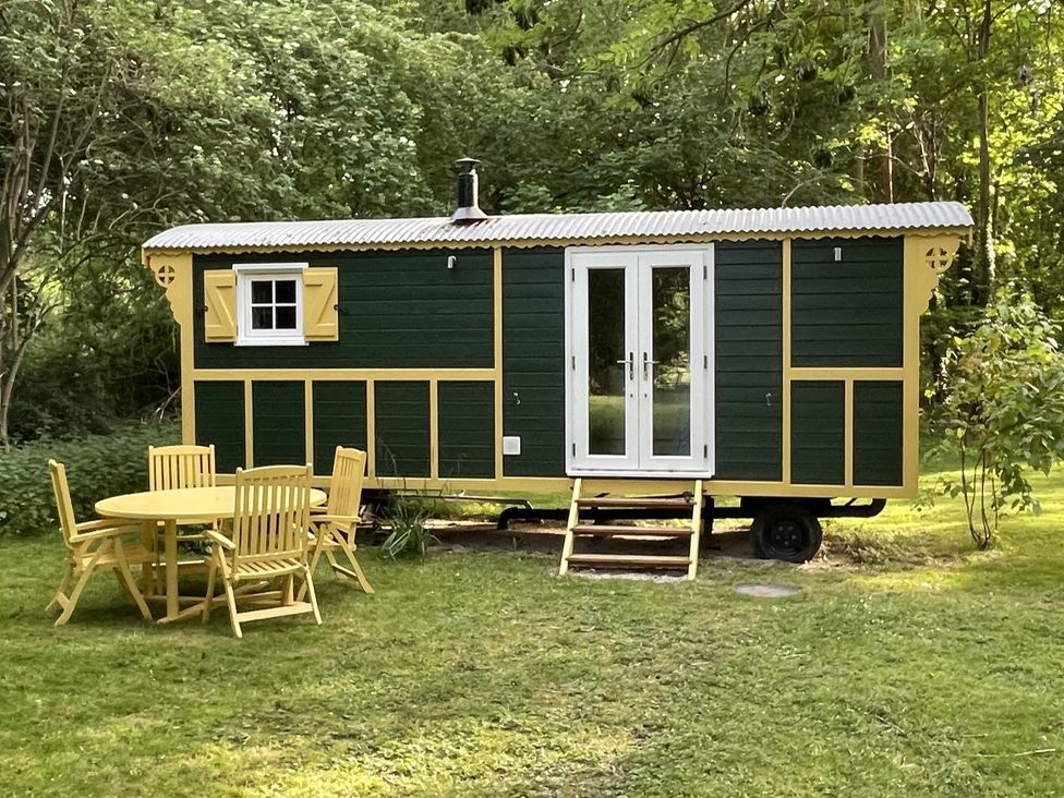 A shepherd hut with steps and garden furniture at The Shepherds Hut in Wallingford