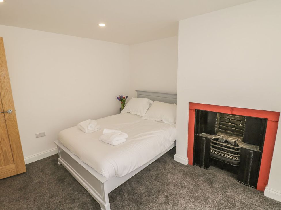A bedroom with a double bed and a fireplace at 47 Baxtergate, Whitby