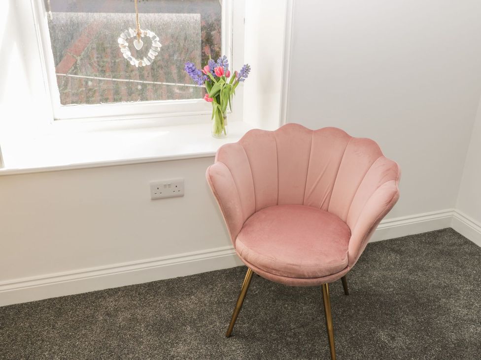 A chair and flowers on a window sill at 47 Baxtergate Whitby