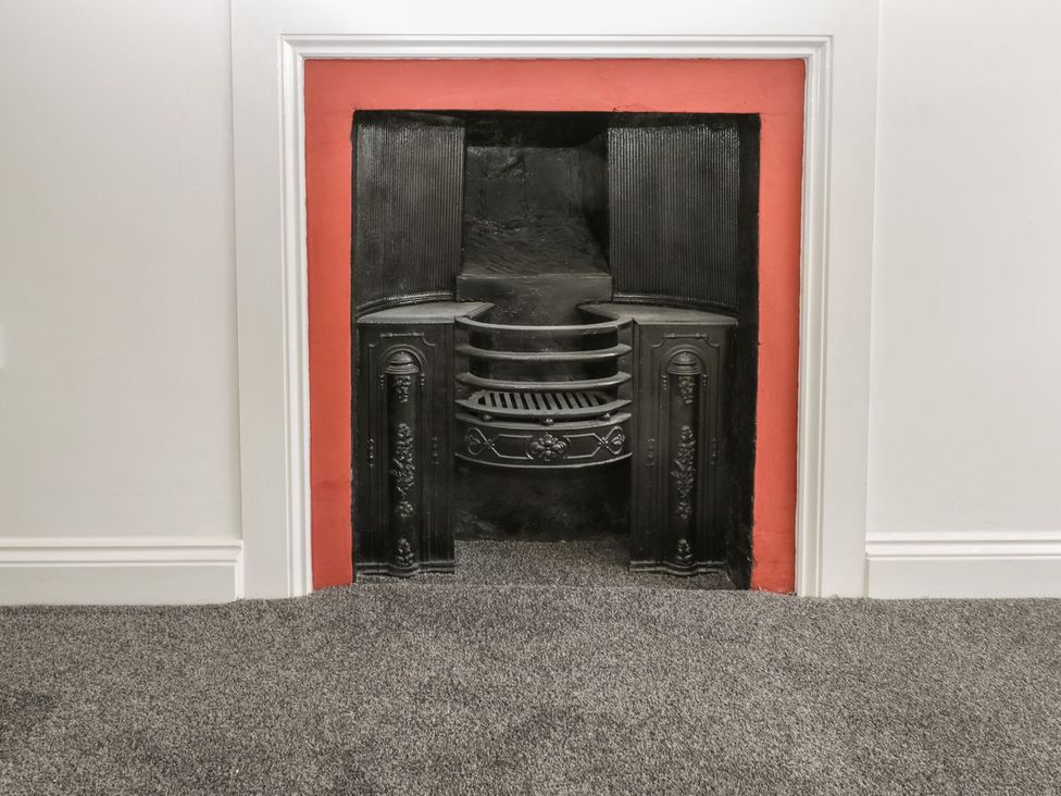 A fireplace with a red surround in a living room at 47 Baxtergate in Whitby