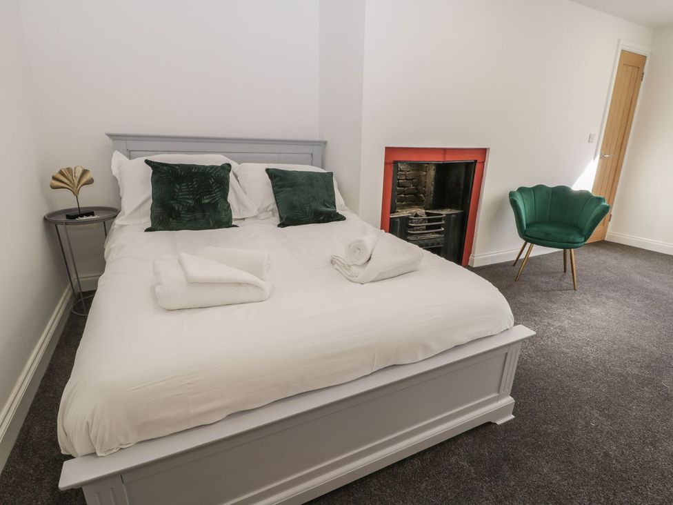 A bedroom with a bed and chair at 47 Baxtergate in Whitby