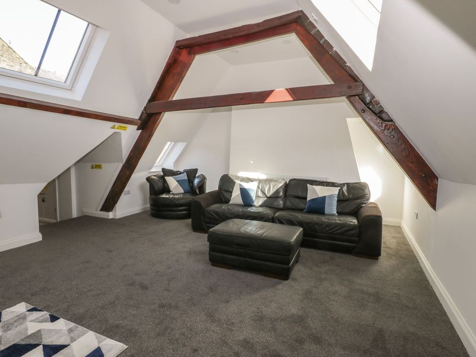 A living room with a sofa and ottoman at 47 Baxtergate in Whitby