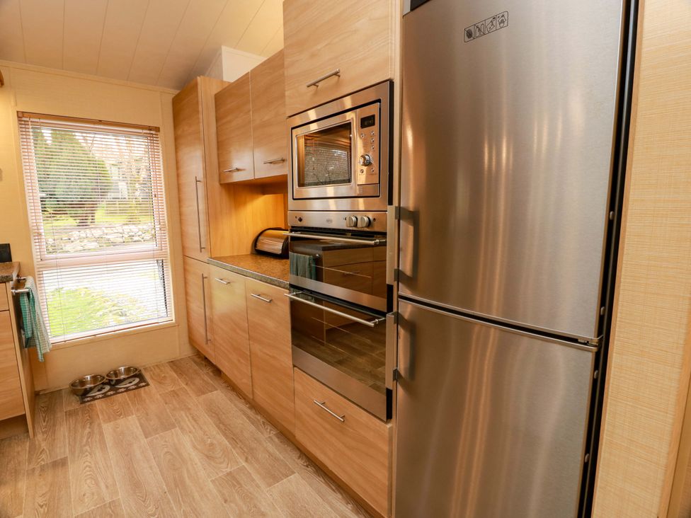 A kitchen with a refrigerator, oven and window at L21 Coastal Kippford in Kippford near Sandyhills