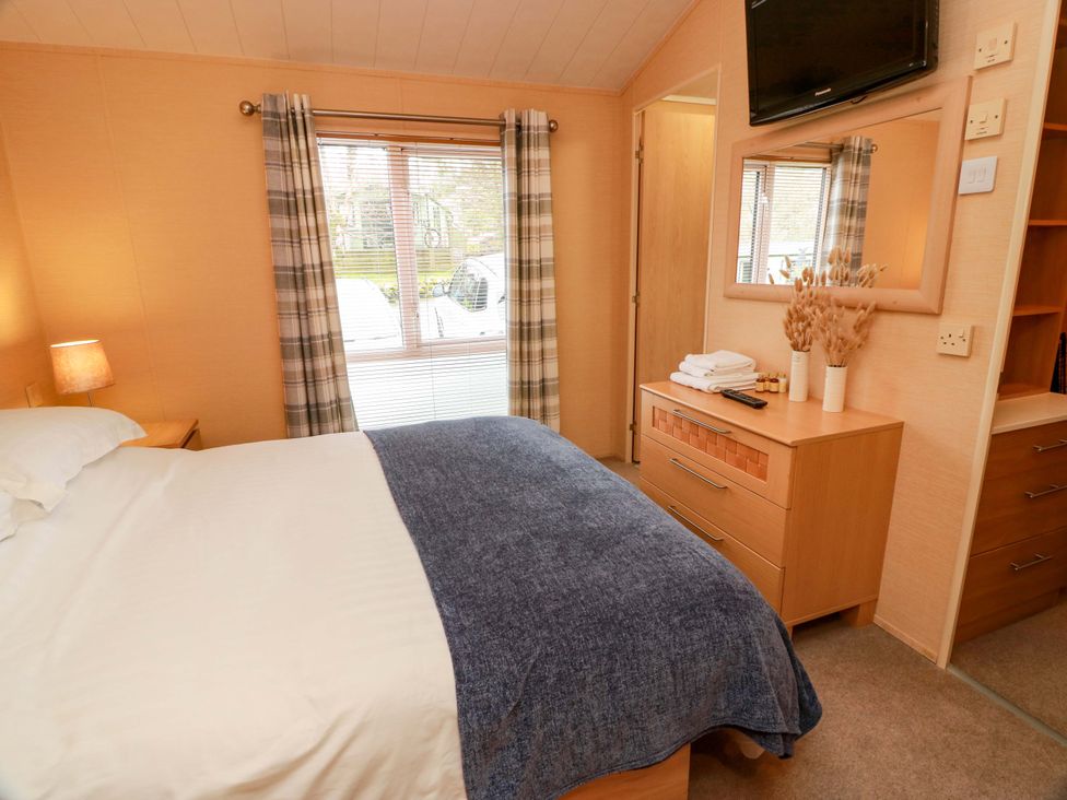 A bedroom with a bed and dresser at L21 Coastal Kippford in Kippford near Sandyhills