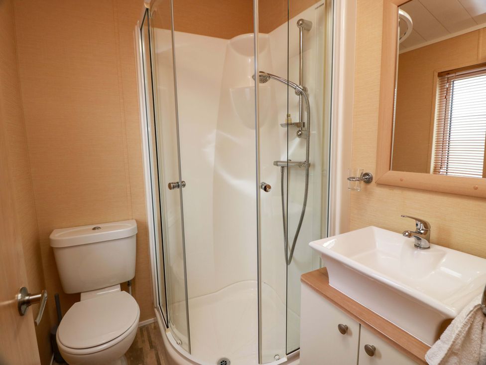 A bathroom with a shower, toilet, and sink at L21 Coastal Kippford near Kippford