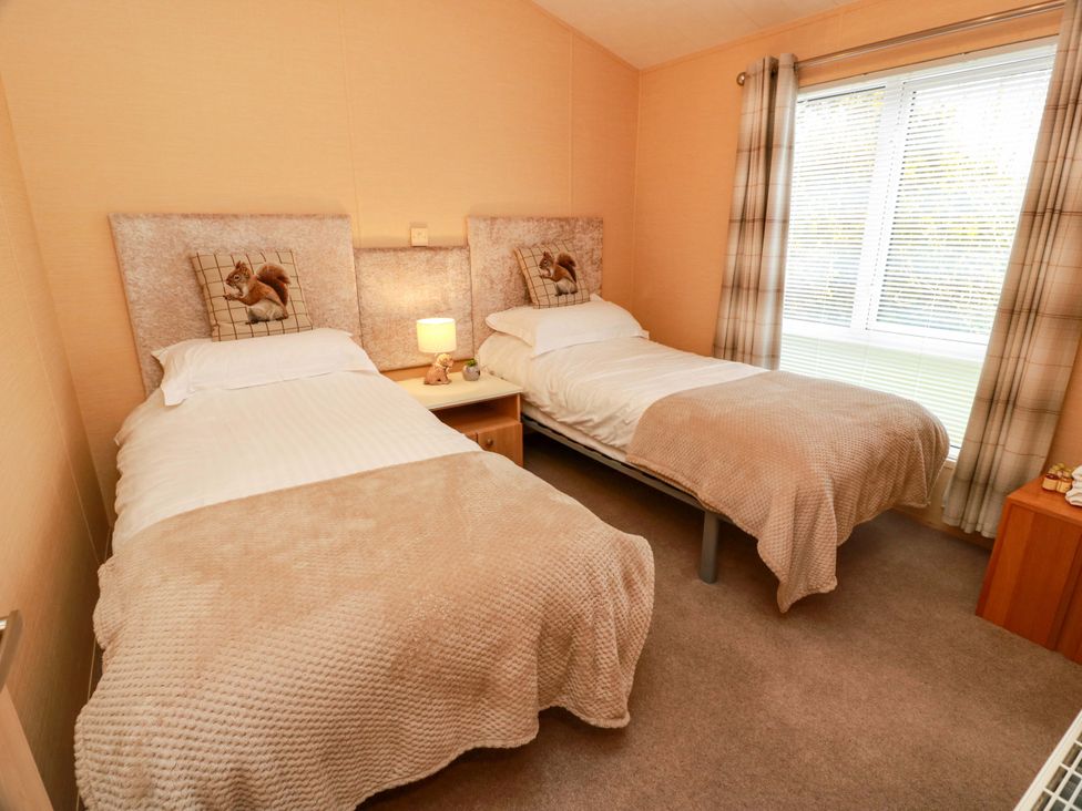A bedroom with two single beds and a bedside table at L21 Coastal Kippford near Kippford