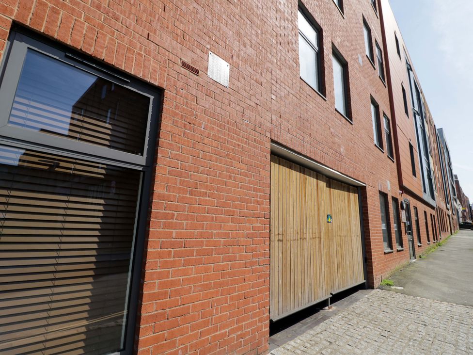 A brick wall with a window and a garage door at Apartment 15 in Birmingham