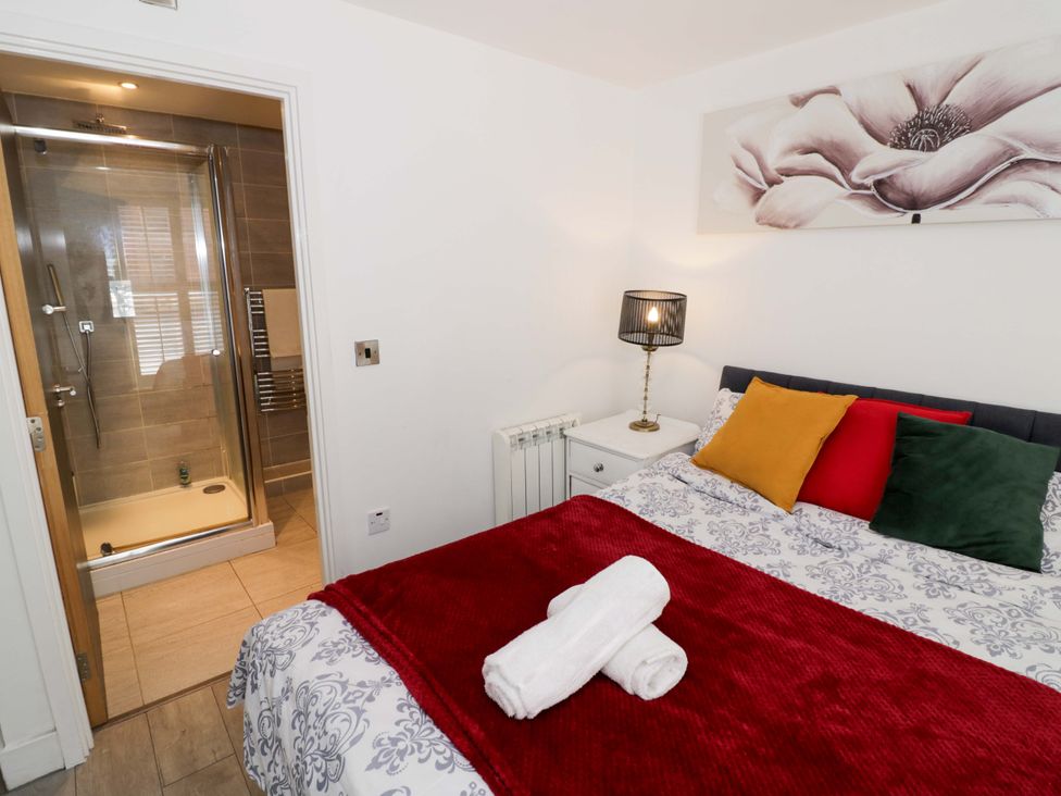 A bedroom with a bed and attached shower room at Apartment 15 Birmingham