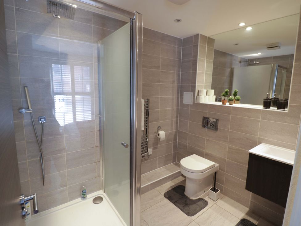 A bathroom with a shower, toilet, and sink at Apartment 15 in Birmingham