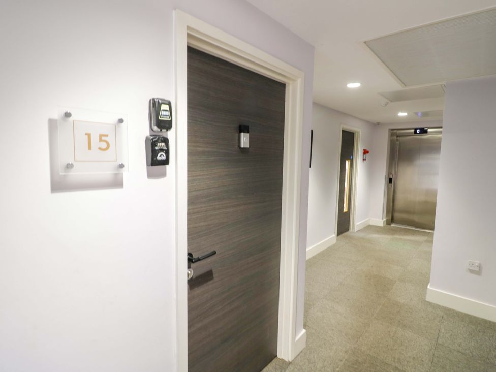 A hallway with door number 15 and an elevator at Apartment 15 in Birmingham