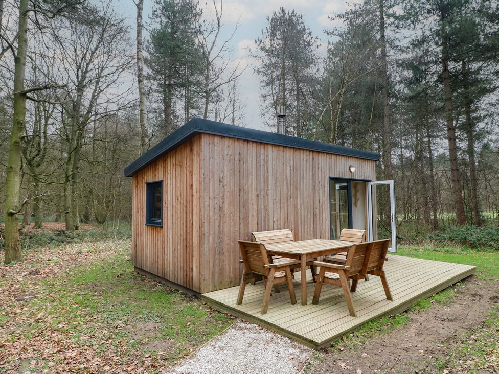 A cabin with a deck and seating area at Sherwood - Family Pod 1 in Mansfield