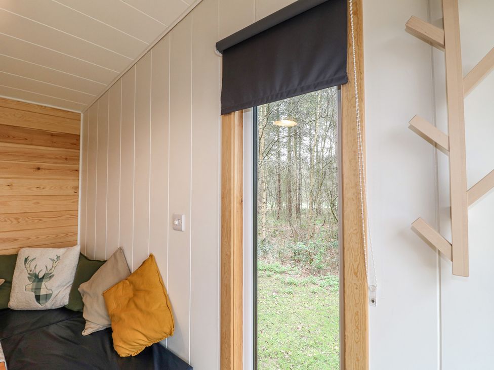 A snug room with a window and cushions at Sherwood - Family Pod 1, Mansfield