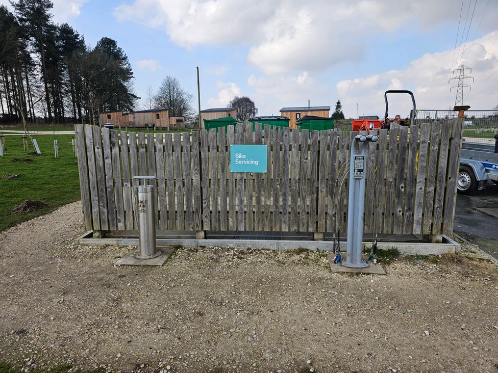 An outdoor bike servicing station with wooden fence and air pump at Sherwood - Family Pod 2 in Mansfield