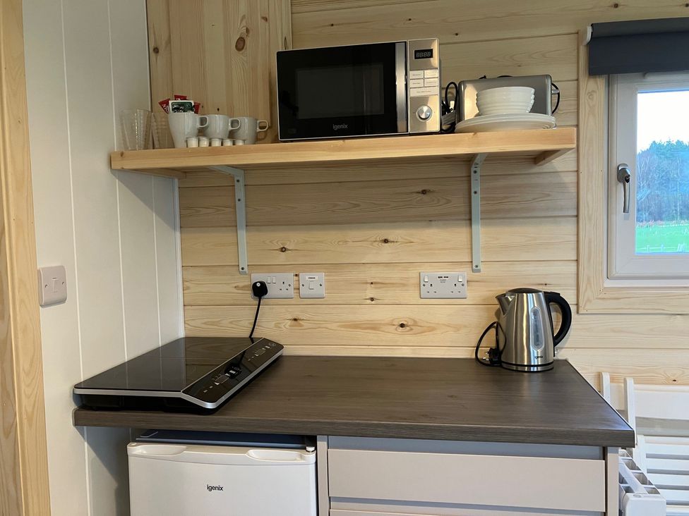 A kitchen with a microwave, kettle, and cooking hob at Sherwood - Family Pod 4 in Mansfield