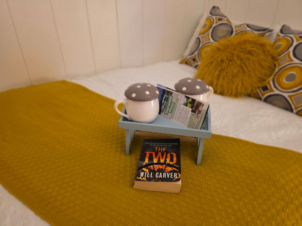 A bedroom with a book and lamps on a table at Sherwood - Family Pod 4 Mansfield