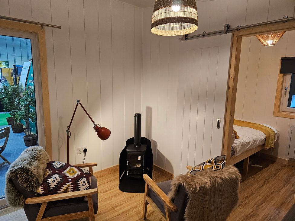 A snug with a wood stove and seating area at Sherwood - Family Pod 5 in Mansfield