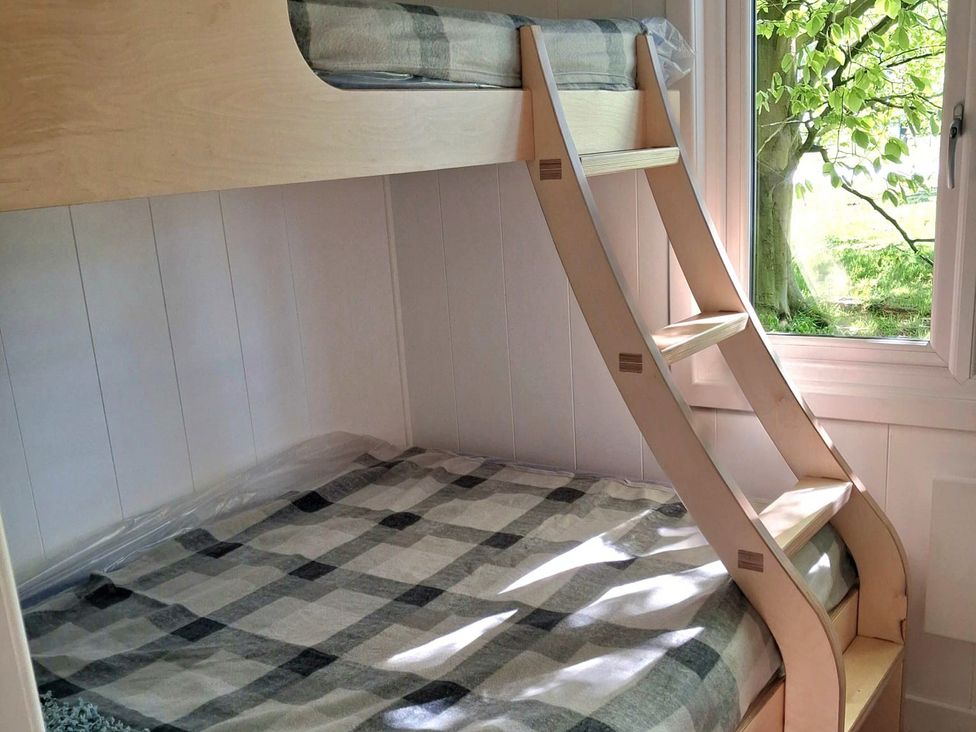 A bunk bed with a ladder in a bedroom at Sherwood Pines - Deluxe Pod 1 near Edwinstowe