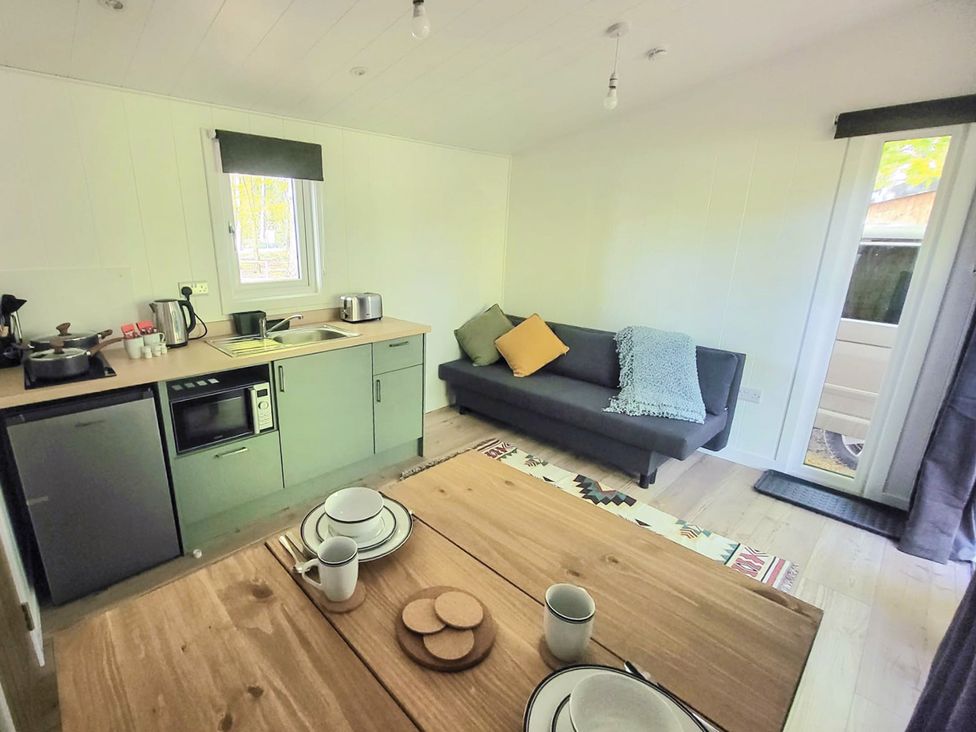 A kitchen and living area with a couch and dining table at Sherwood Pines - Deluxe Pod 1 near Edwinstowe