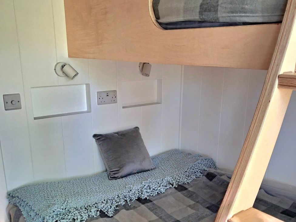 A bedroom with a bunk bed and a cushion at Sherwood Pines - Deluxe Pod 2 near Edwinstowe