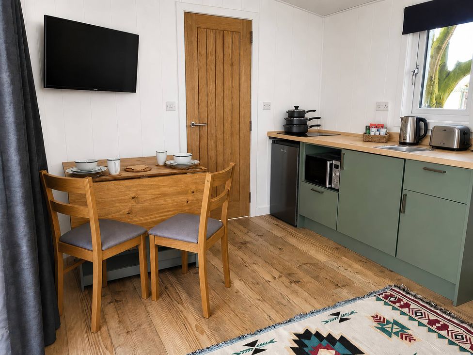 A kitchen with dining table and two chairs at Sherwood Pines - Deluxe Pod 2 near Edwinstowe