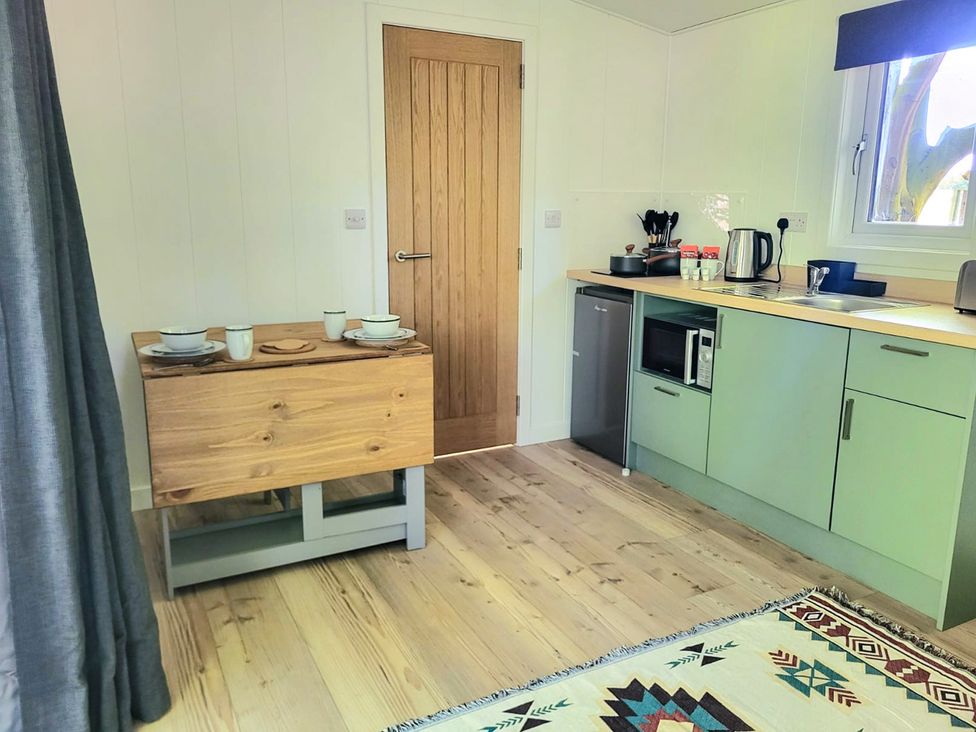 A kitchen with a table and kitchen appliances at Sherwood Pines - Deluxe Pod 2 near Edwinstowe