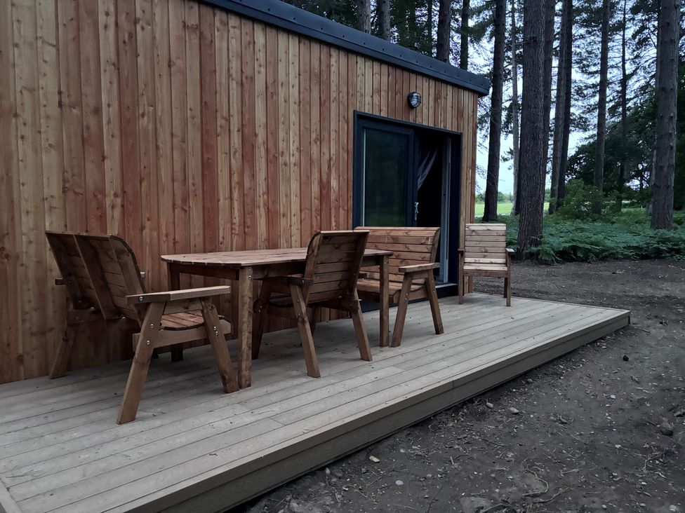 A wooden table and chairs on a deck at Sherwood Pines - Deluxe Pod 2 near Edwinstowe