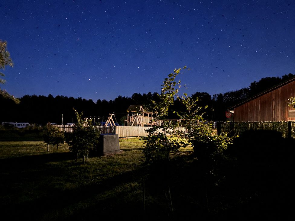 A playground area with trees and stars in the night sky at Sherwood Pines - Deluxe Pod 2 near Edwinstowe