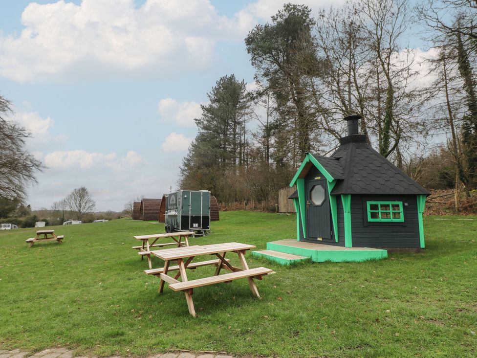 An outdoor area with a hut and picnic tables at Sherwood Pines - Deluxe Pod 3 near Edwinstowe