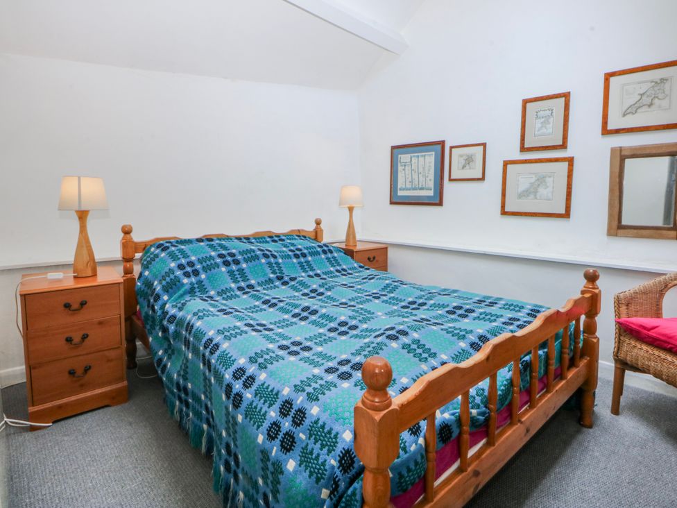 A bedroom with a bed and nightstands at Llwyn Y Brig Isaf in Caernarfon