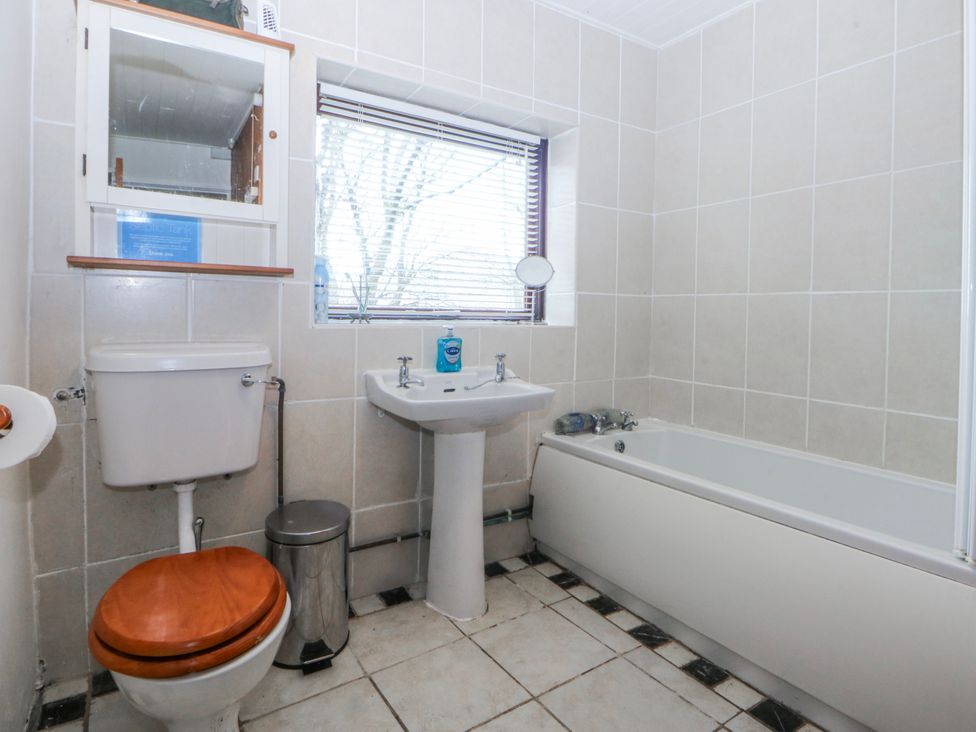 A bathroom with a toilet, sink, and bathtub at Llwyn Y Brig Isaf in Caernarfon