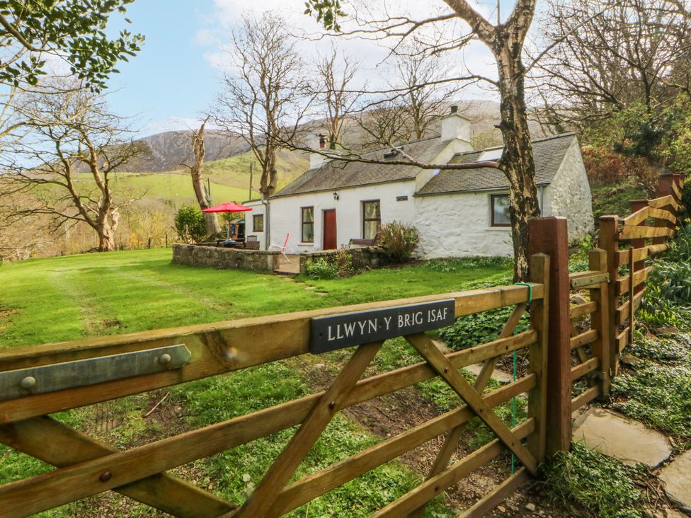 A cottage with a gate and lawn at Llwyn Y Brig Isaf in Caernarfon