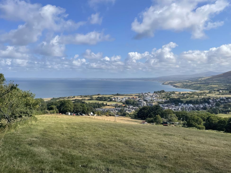 A view of a coastal landscape with a town near the shore at Llwyn Y Brig Isaf in Trefor