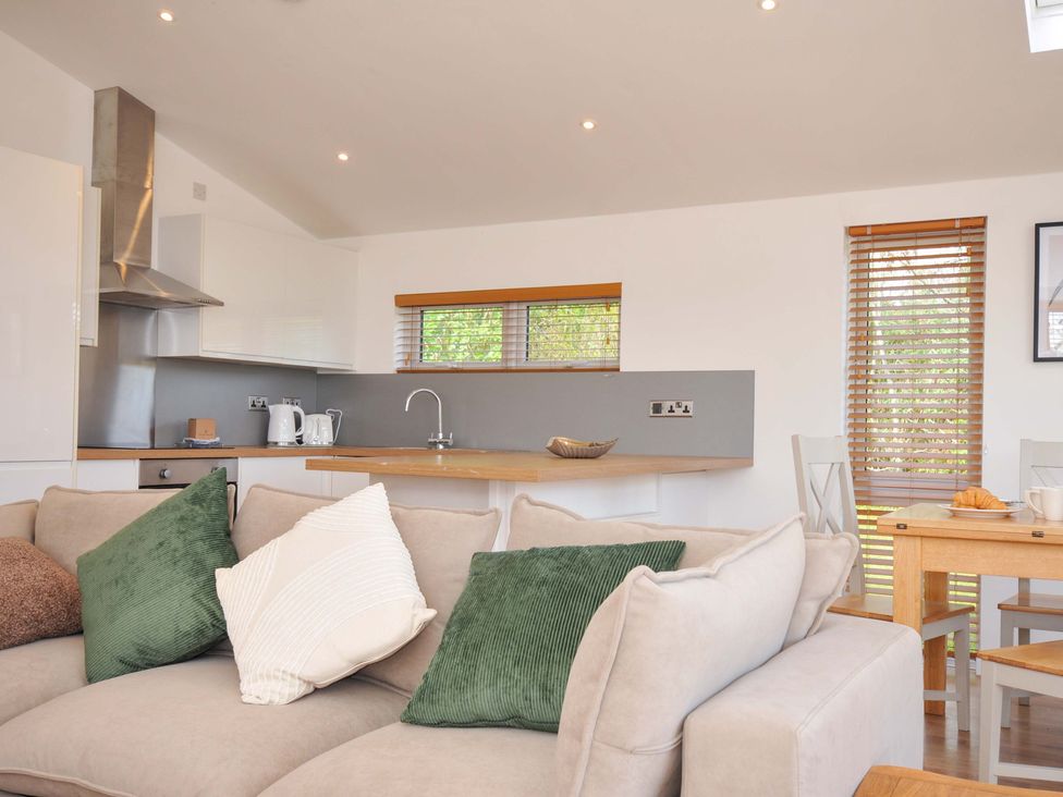A living room with a kitchen area and dining table at 3 Faraway Fields in Dobwalls