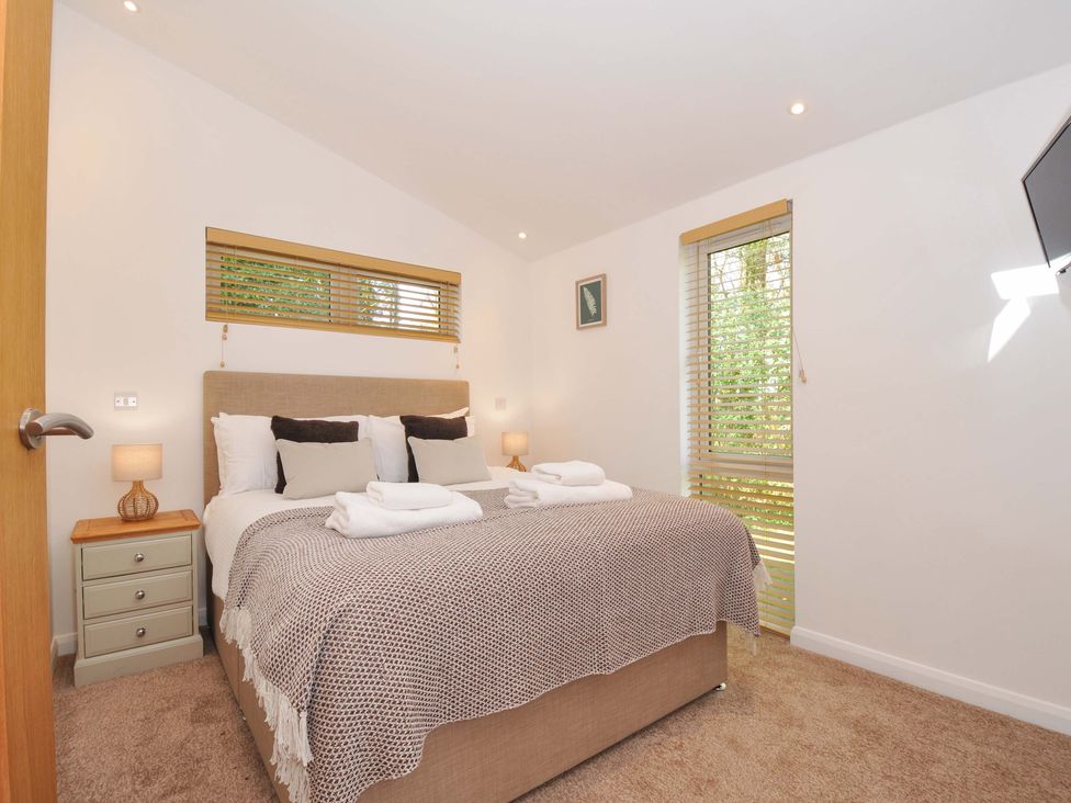 A bedroom with a bed and bedside tables at 3 Faraway Fields in Dobwalls