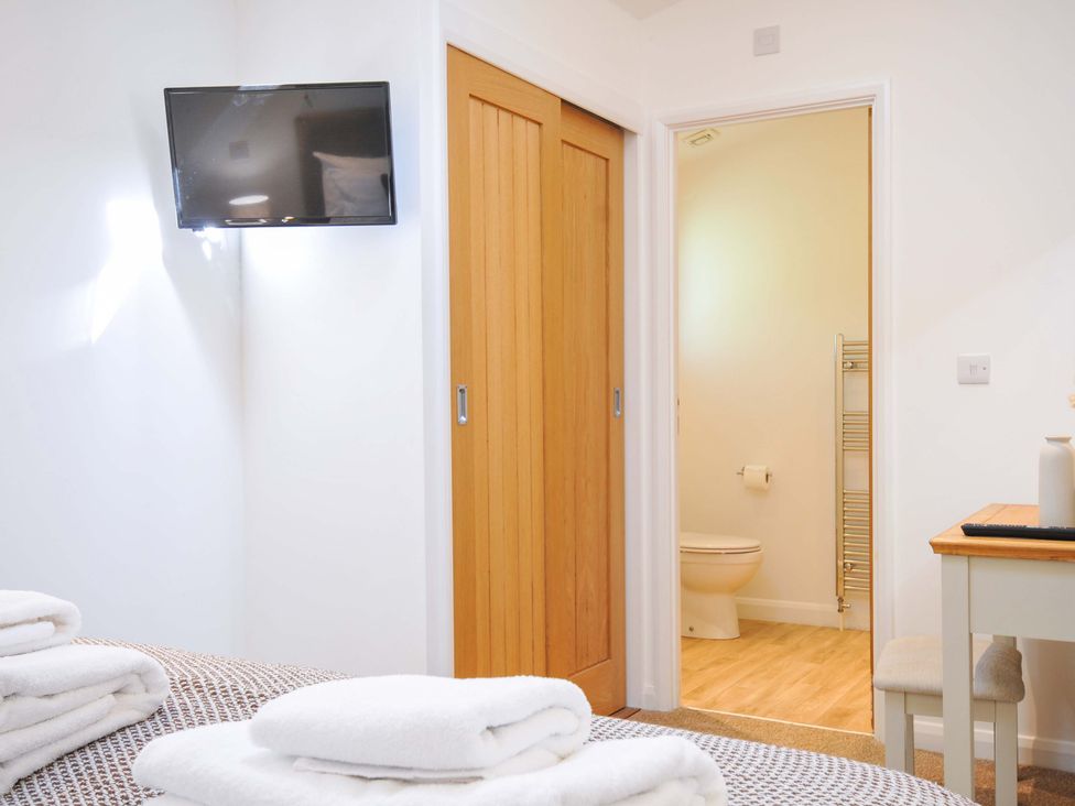 A bedroom with a television and an entryway to a bathroom at 3 Faraway Fields in Dobwalls