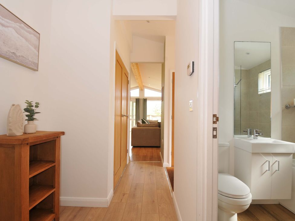 A hallway with a wooden shelf and bathroom door at 3 Faraway Fields in Dobwalls