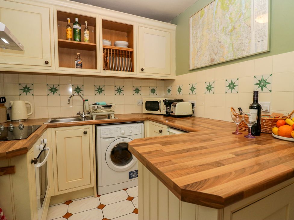 A kitchen with appliances and fruit bowl at Corner Cottage in Lowick Green near Ulverston
