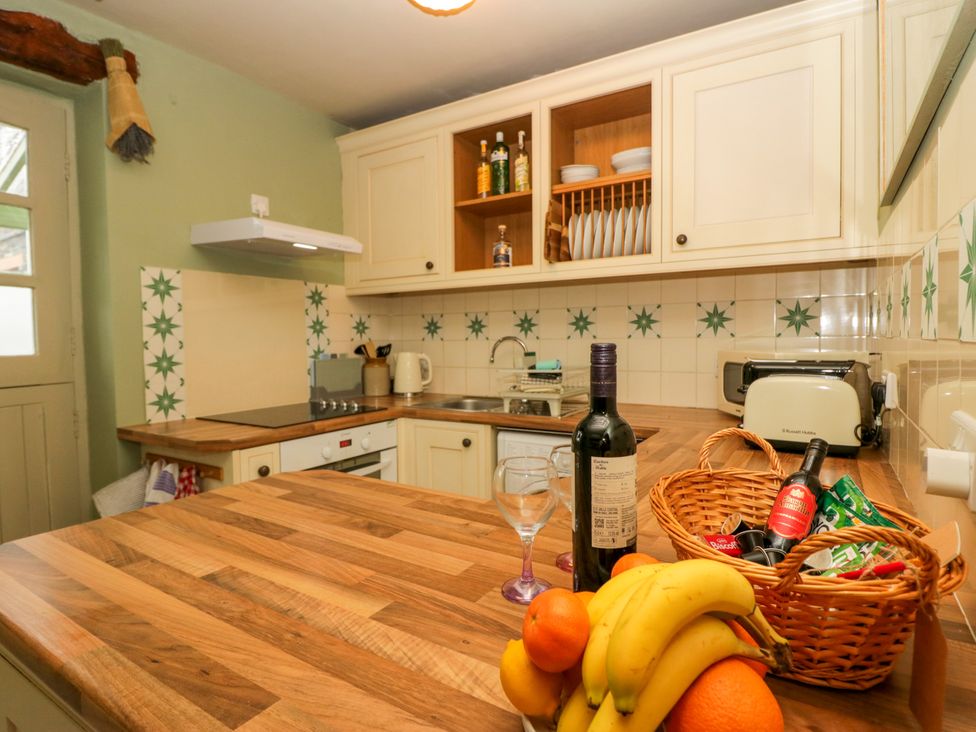 A kitchen with countertop, sink, and fruit basket at Corner Cottage, Lowick Green near Ulverston