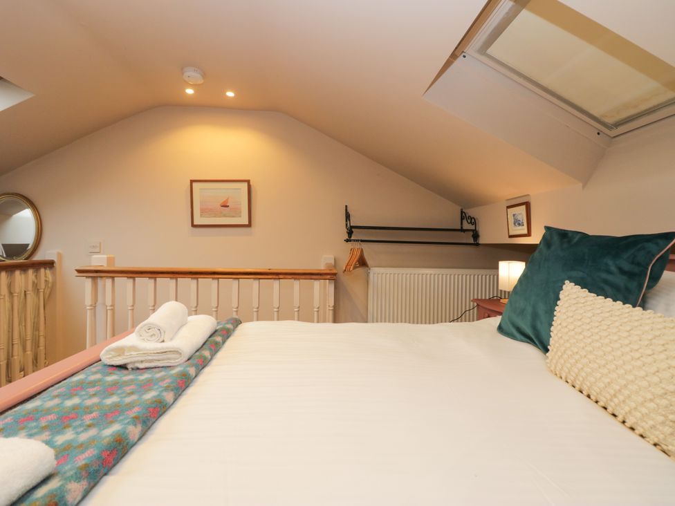 A bedroom with a bed and decorative items at Corner Cottage in Lowick Green near Ulverston